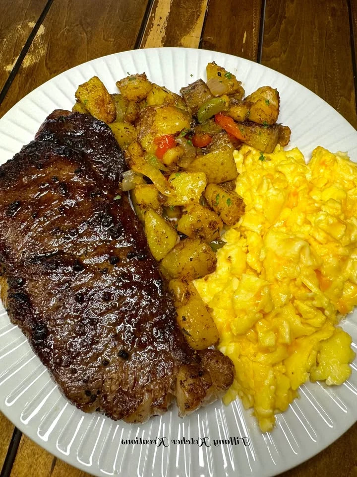 Steak, cheesy eggs and fried potatoes finished