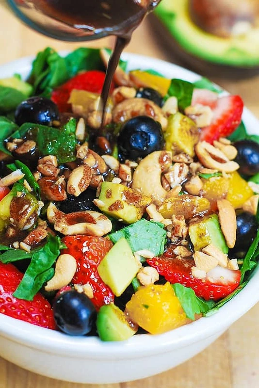Strawberry and Spinach Salad with Mango, Avocado, Blueberries, and Cashew Nuts, tossed with a simple homemade balsamic vinaigrette. finished